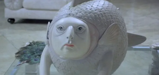 A bewildering ceramic fish-with-a-human-face sculpture, peak 80s Florida decor, in the villain's lair in Licence to Kill