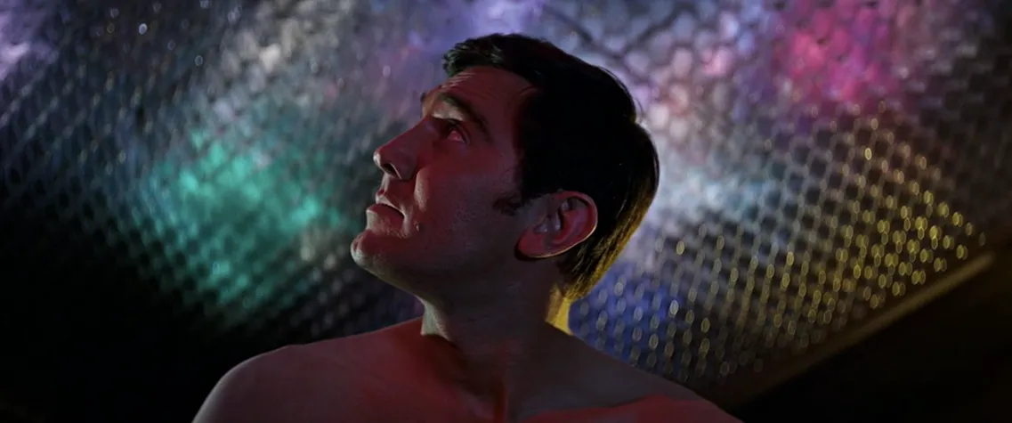 George Lazenby gazes upward, bathed in psychedelic coloured light, in On Her Majesty's Secret Service