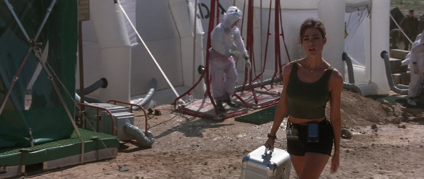 Denise Richards as nuclear physicist Dr. Christmas Jones, striding through a decontamination site in The World Is Not Enough